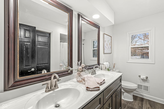 bathroom with hardwood / wood-style flooring, vanity, and toilet