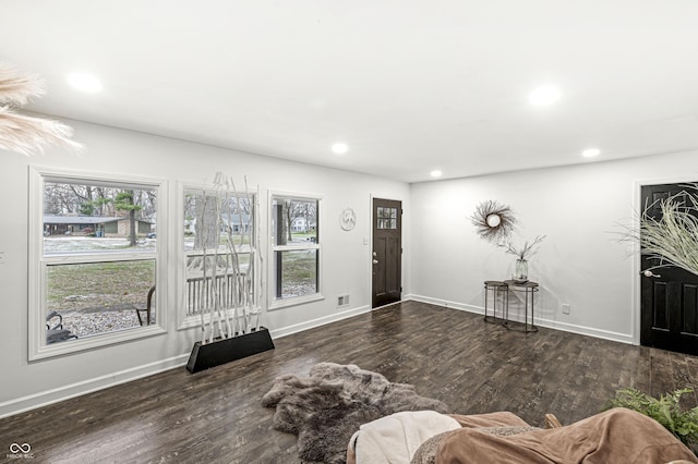 living room with a healthy amount of sunlight and dark wood-type flooring