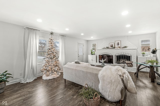 living room featuring dark hardwood / wood-style flooring and a brick fireplace