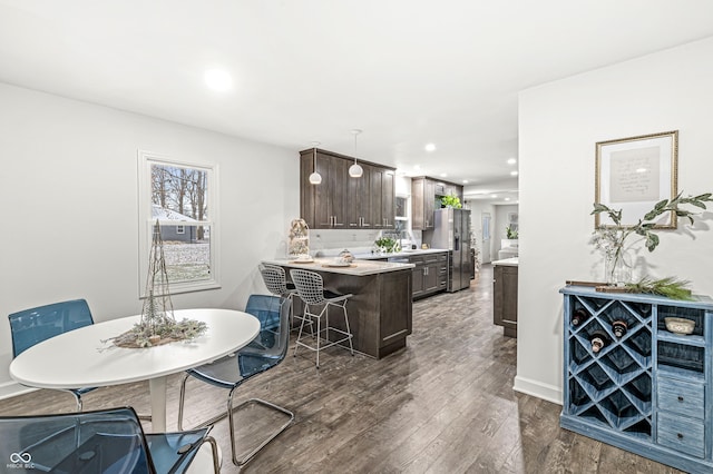 dining space featuring dark wood-type flooring and sink