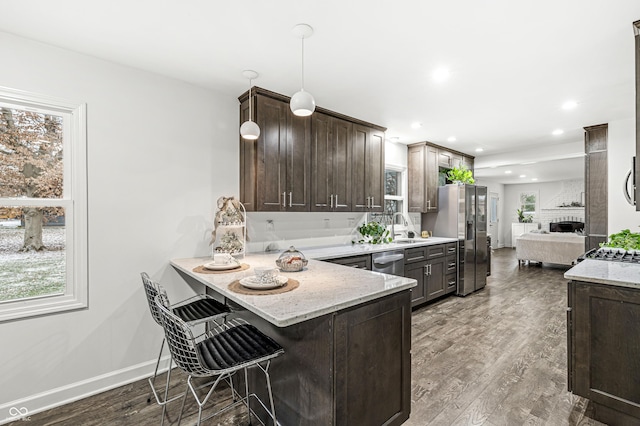 kitchen featuring a kitchen bar, kitchen peninsula, plenty of natural light, and stainless steel appliances