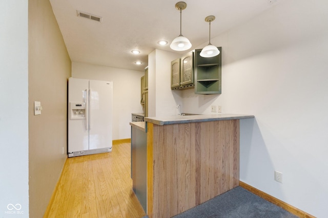 kitchen with kitchen peninsula, white fridge with ice dispenser, hanging light fixtures, and light hardwood / wood-style flooring