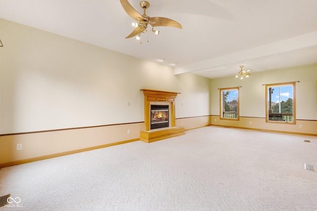 unfurnished living room featuring carpet flooring and ceiling fan with notable chandelier