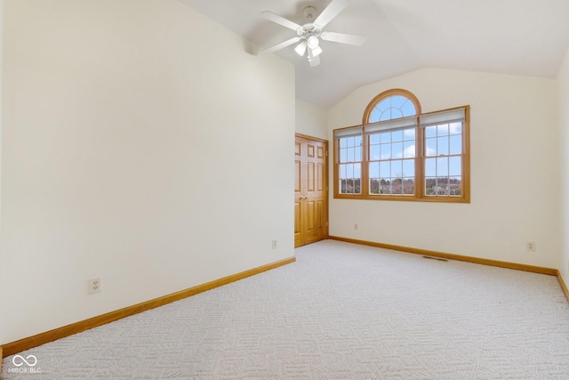 carpeted empty room with ceiling fan and vaulted ceiling