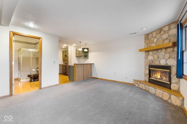 unfurnished living room featuring a fireplace and light colored carpet