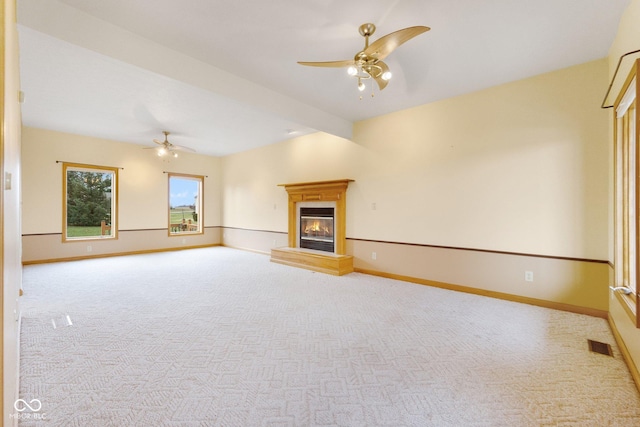 unfurnished living room with vaulted ceiling with beams, ceiling fan, and light colored carpet