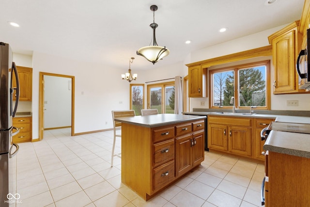 kitchen featuring appliances with stainless steel finishes, sink, decorative light fixtures, a notable chandelier, and a center island