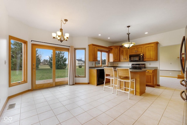 kitchen with black appliances, an inviting chandelier, a center island, hanging light fixtures, and a breakfast bar area