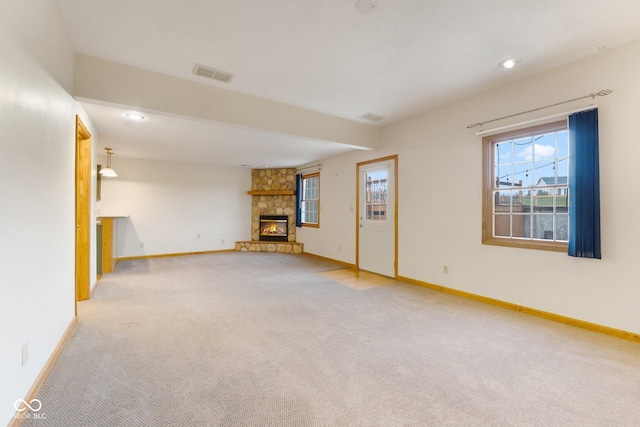 unfurnished living room with light carpet and a fireplace