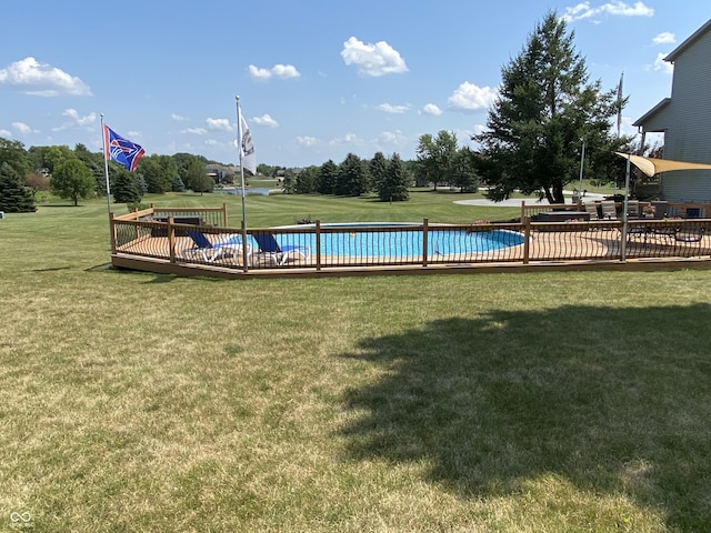 view of swimming pool featuring a yard