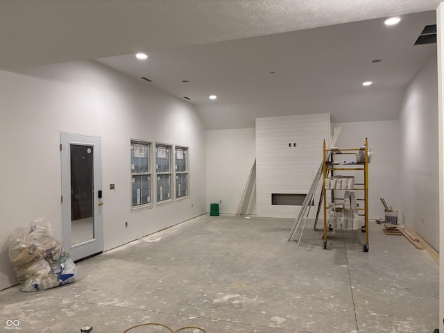 misc room with lofted ceiling and a textured ceiling