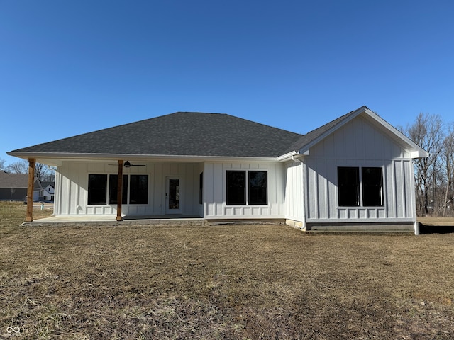 rear view of house with a shingled roof, a ceiling fan, board and batten siding, and a patio