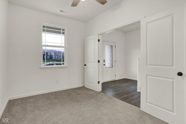 spare room with ceiling fan and dark carpet