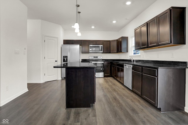 kitchen with dark hardwood / wood-style floors, a kitchen island, hanging light fixtures, and appliances with stainless steel finishes