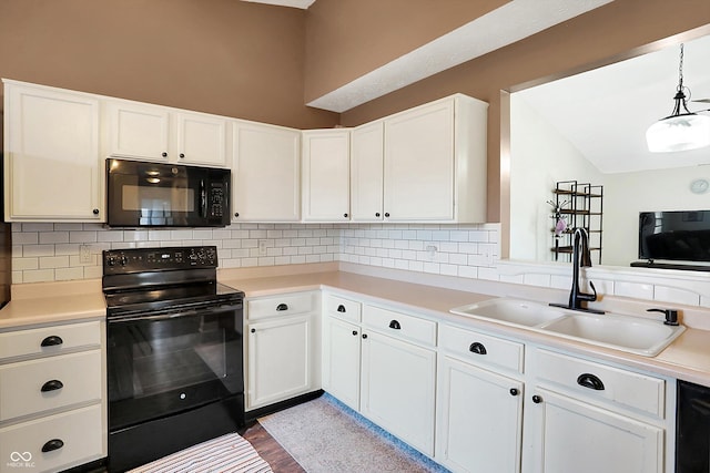 kitchen featuring white cabinetry, sink, pendant lighting, wood-type flooring, and black appliances