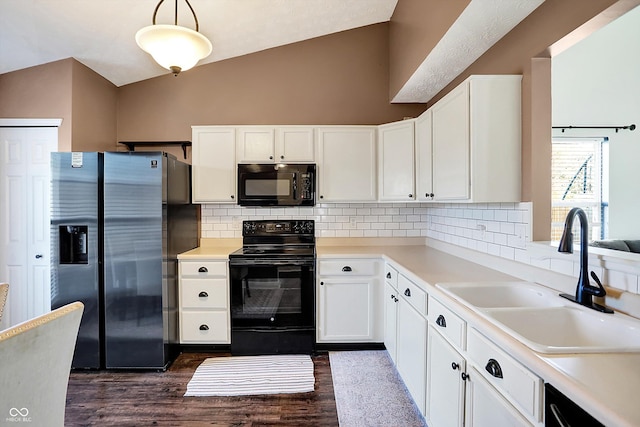 kitchen with hanging light fixtures, white cabinets, black appliances, and vaulted ceiling