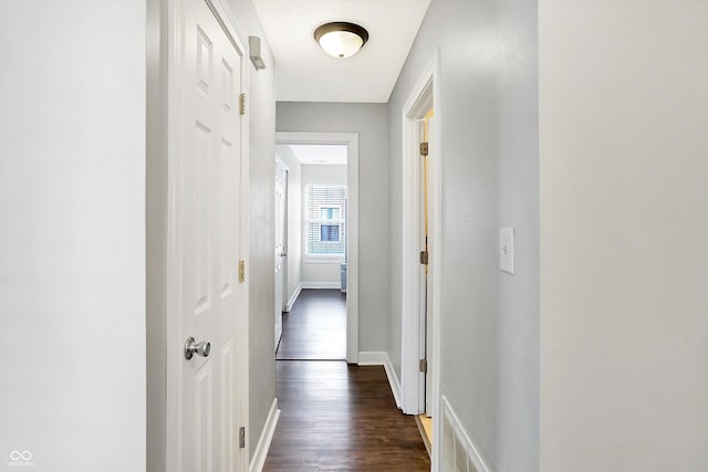 corridor with dark hardwood / wood-style flooring