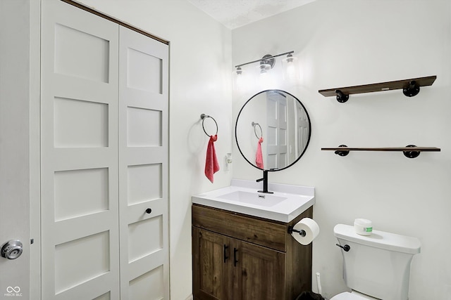 bathroom with vanity, a textured ceiling, and toilet