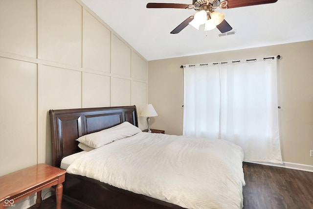 bedroom with ceiling fan, dark wood-type flooring, and vaulted ceiling