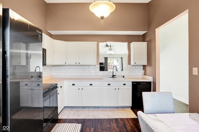 kitchen with dark hardwood / wood-style flooring, sink, white cabinets, and black appliances