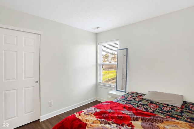 bedroom with a textured ceiling and dark hardwood / wood-style floors