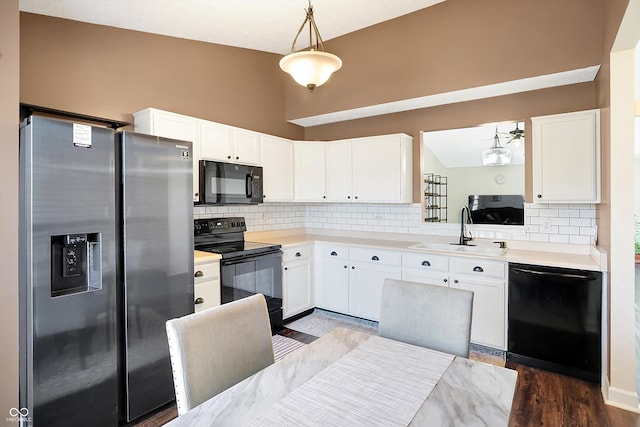 kitchen featuring hanging light fixtures, sink, white cabinets, and black appliances