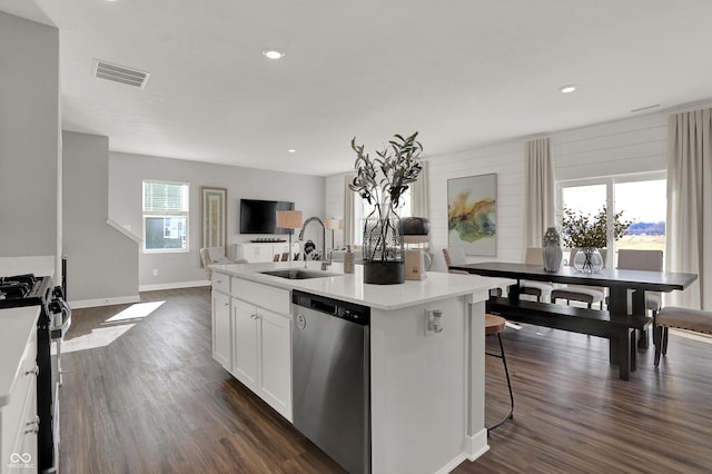 kitchen featuring dishwasher, gas stove, a kitchen island with sink, and a healthy amount of sunlight