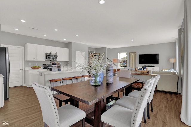 dining space featuring sink and light hardwood / wood-style flooring