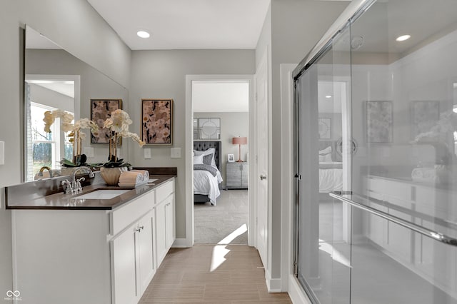 bathroom with a shower with door and vanity