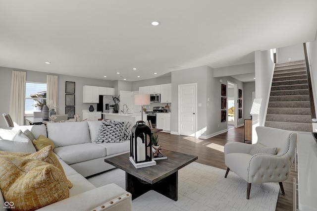 living room with light hardwood / wood-style flooring and sink