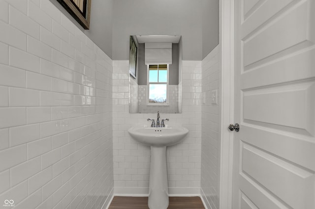 bathroom featuring wood-type flooring and tile walls