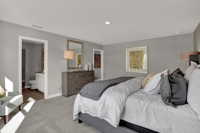 bedroom featuring light carpet and ensuite bath