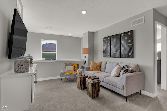 living room featuring light carpet and a textured ceiling