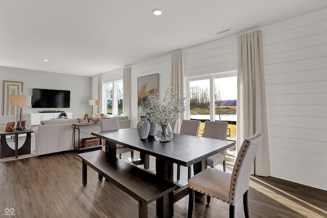 dining area featuring hardwood / wood-style floors and wooden walls