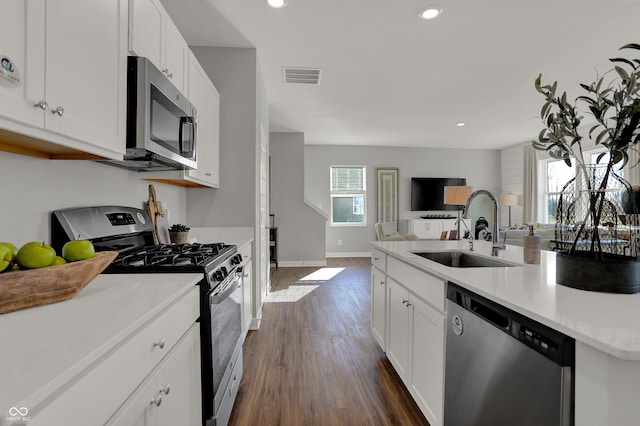 kitchen featuring stainless steel appliances, white cabinetry, dark hardwood / wood-style floors, and sink