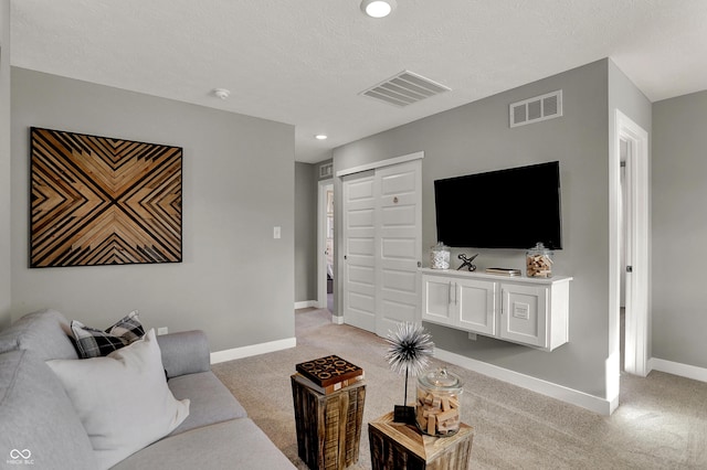 living room with light carpet and a textured ceiling