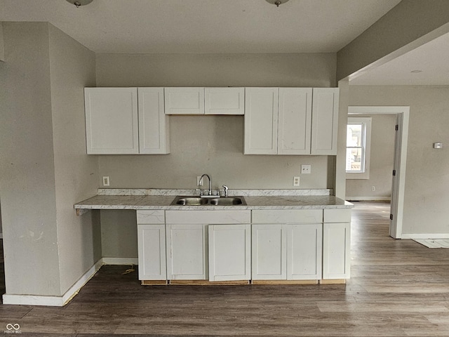 kitchen with white cabinets, hardwood / wood-style floors, and sink