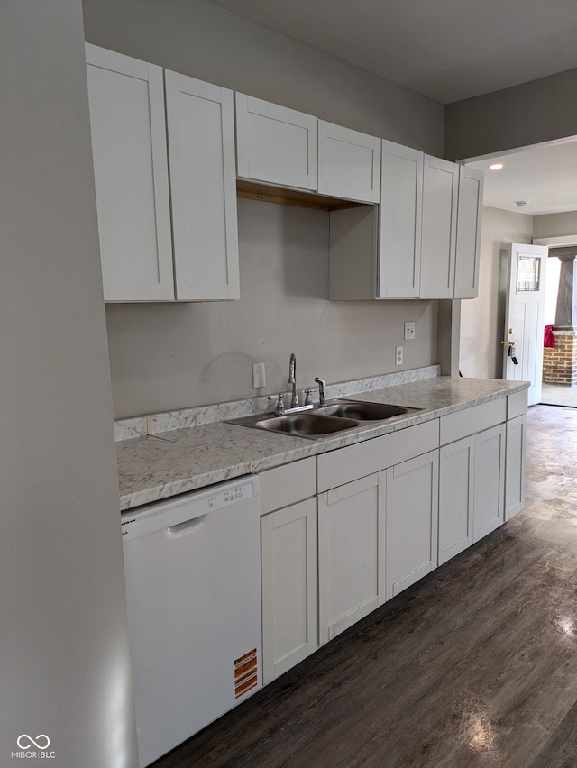 kitchen featuring white dishwasher, a sink, white cabinetry, light countertops, and dark wood-style floors