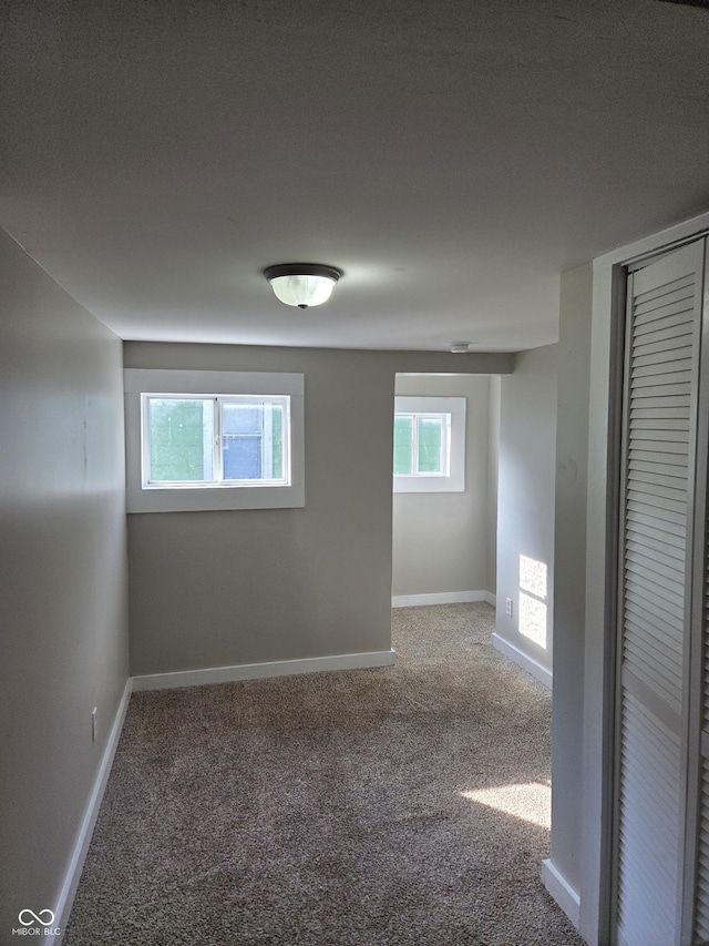 spare room featuring carpet floors and baseboards