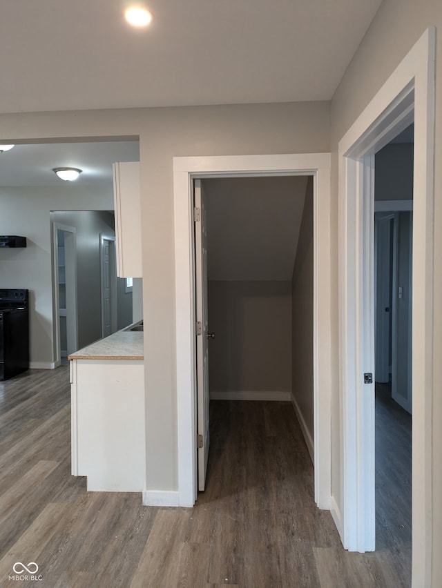 hall featuring dark wood finished floors and baseboards