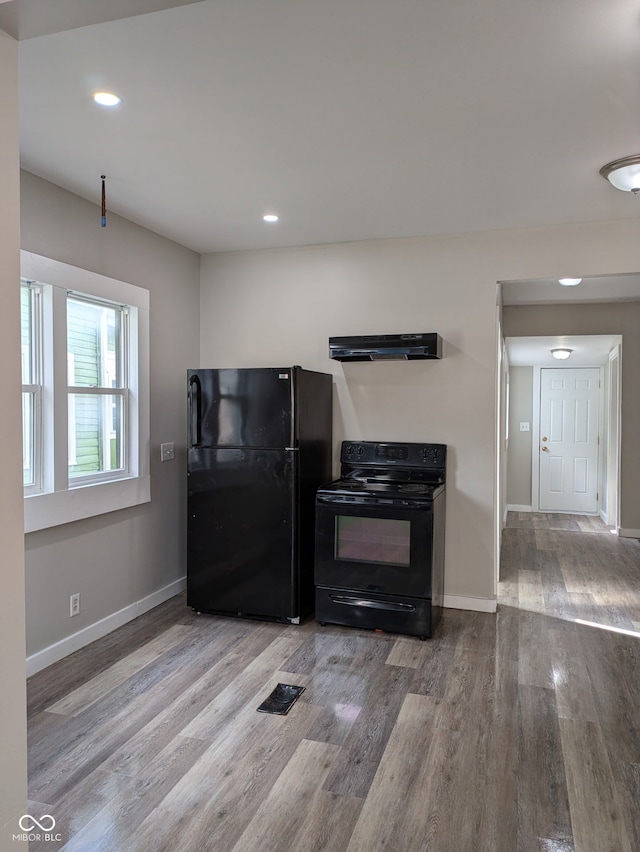 kitchen with recessed lighting, black appliances, wood finished floors, under cabinet range hood, and baseboards