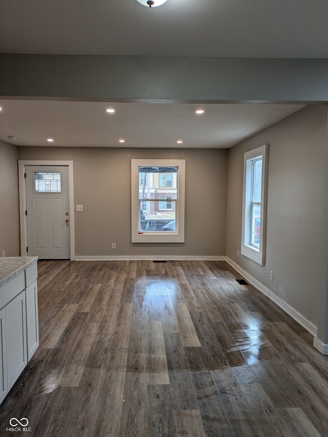 entrance foyer featuring dark wood-type flooring, a wealth of natural light, and baseboards