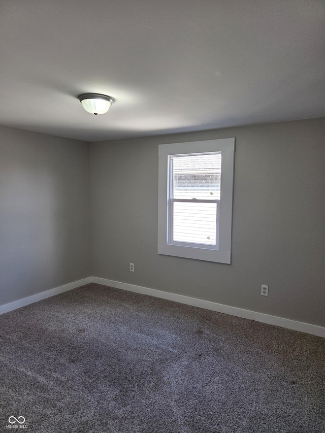 spare room featuring carpet and baseboards