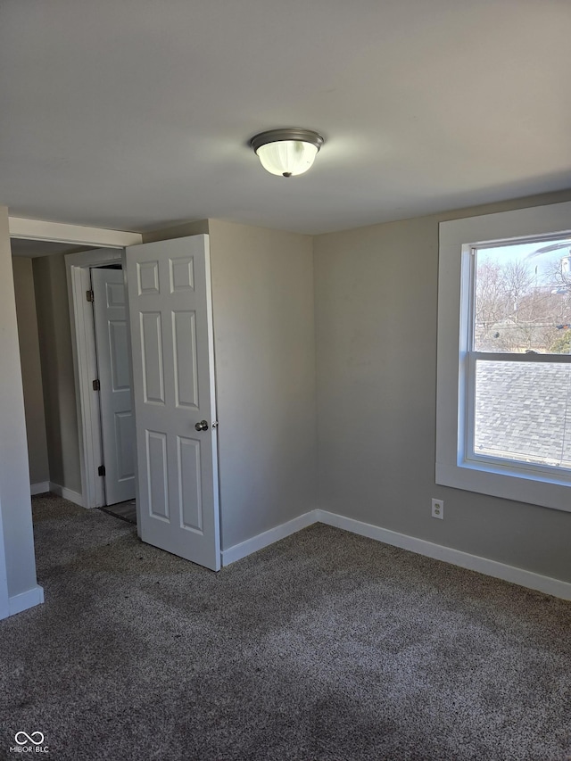 empty room with carpet and baseboards