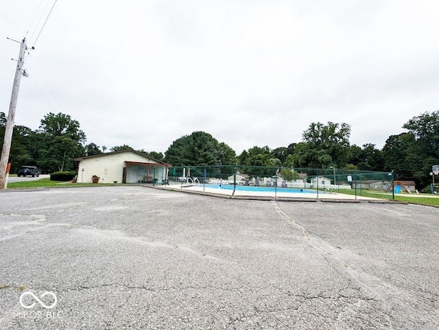 view of car parking featuring a community pool