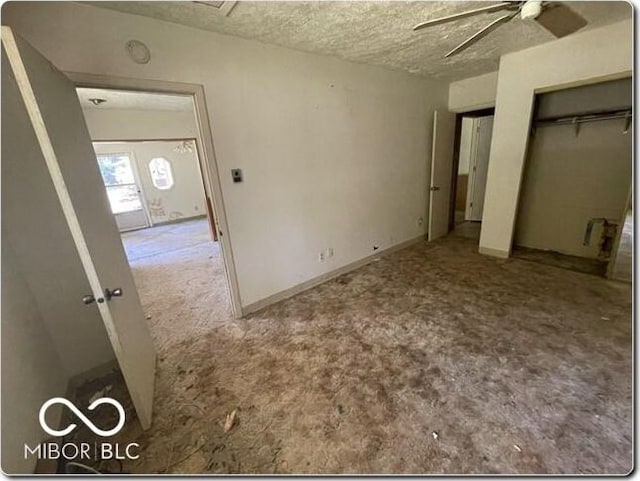 unfurnished bedroom featuring carpet flooring, a textured ceiling, and ceiling fan