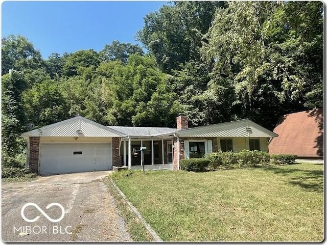 single story home featuring a front lawn and a garage