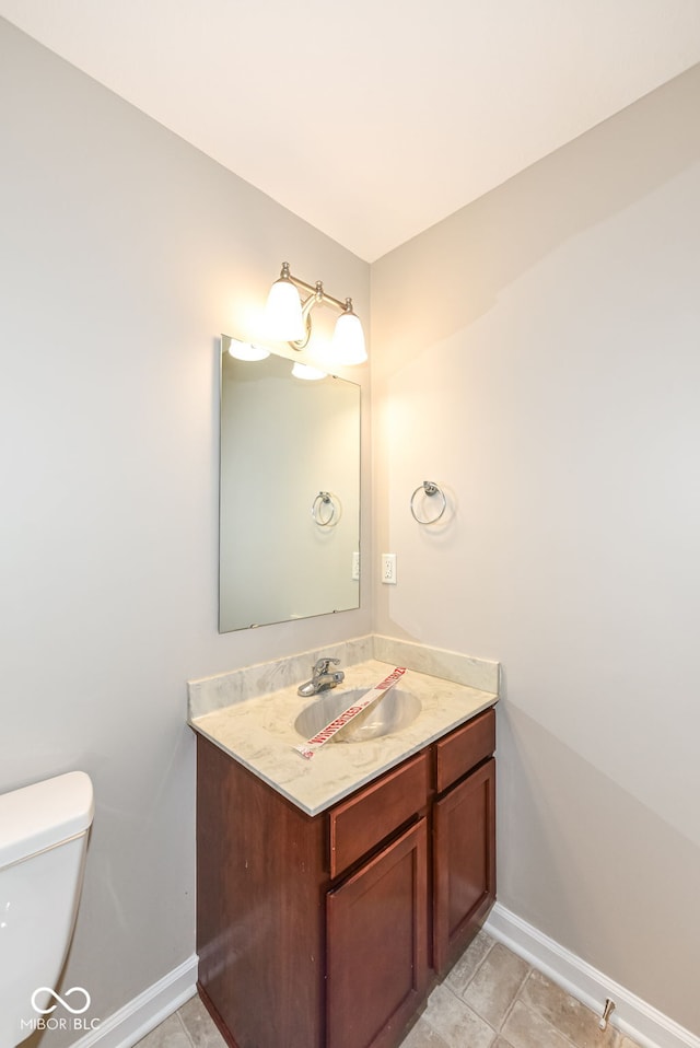 bathroom featuring tile patterned flooring, vanity, and toilet