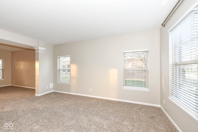 carpeted empty room featuring ornate columns