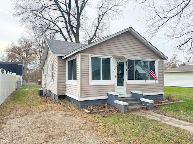 bungalow-style home featuring a front lawn and central air condition unit